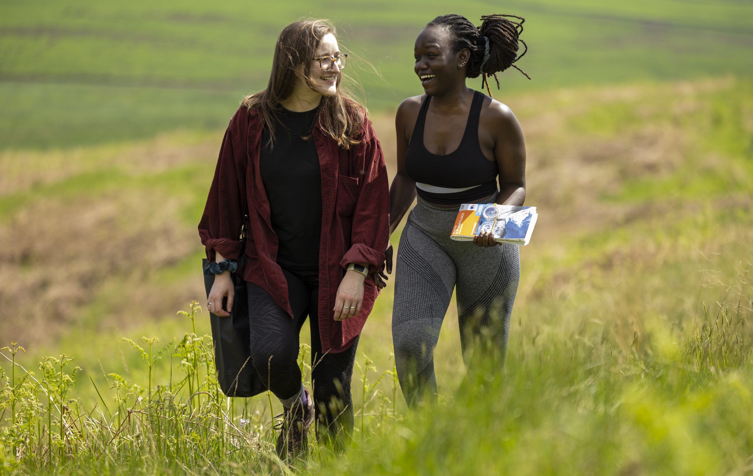 Two women walking across a hillside